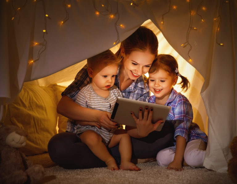 Happy family mother and children playing in tablet  pc